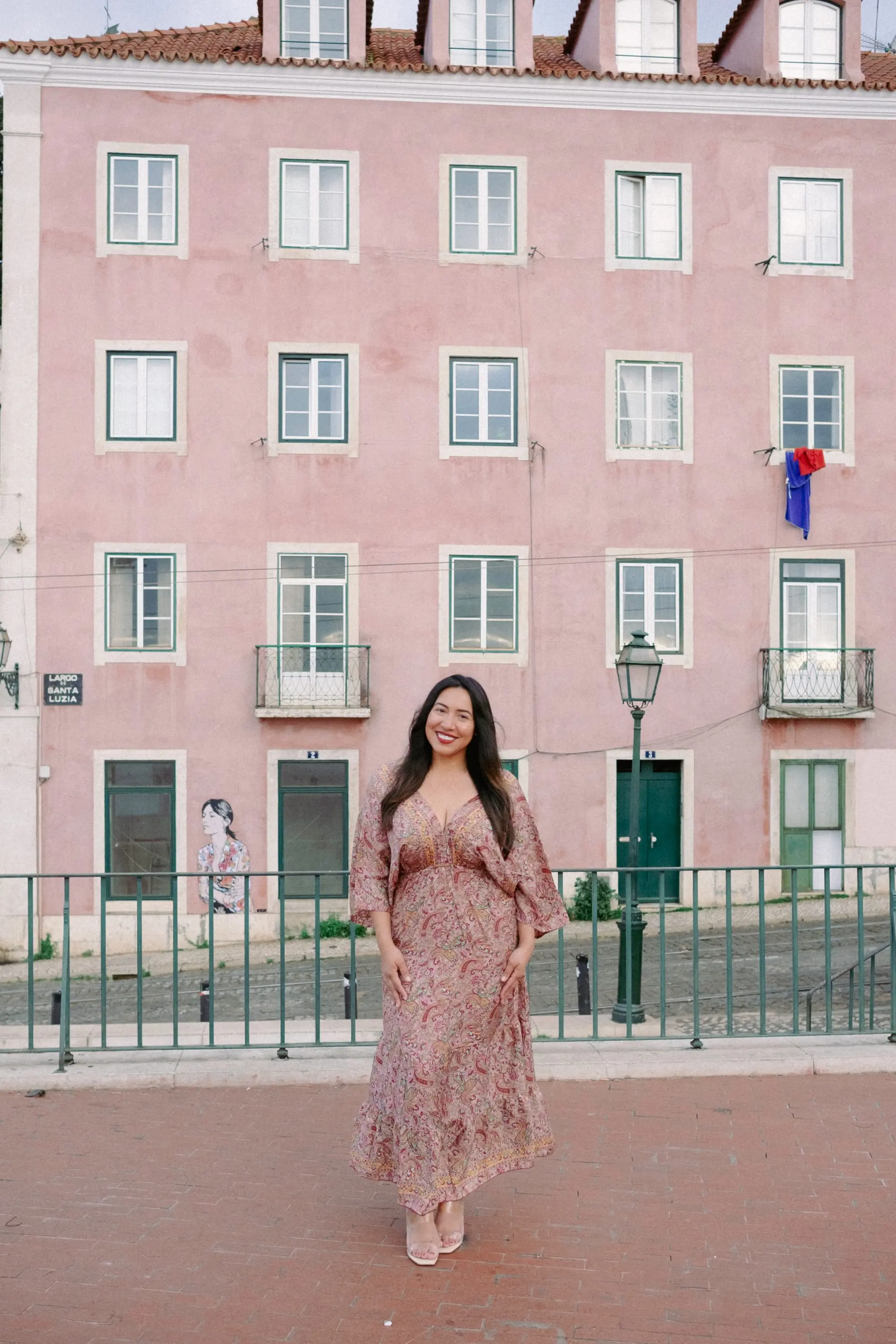 Jeannette Ceja in front of a pink Lisbon façade